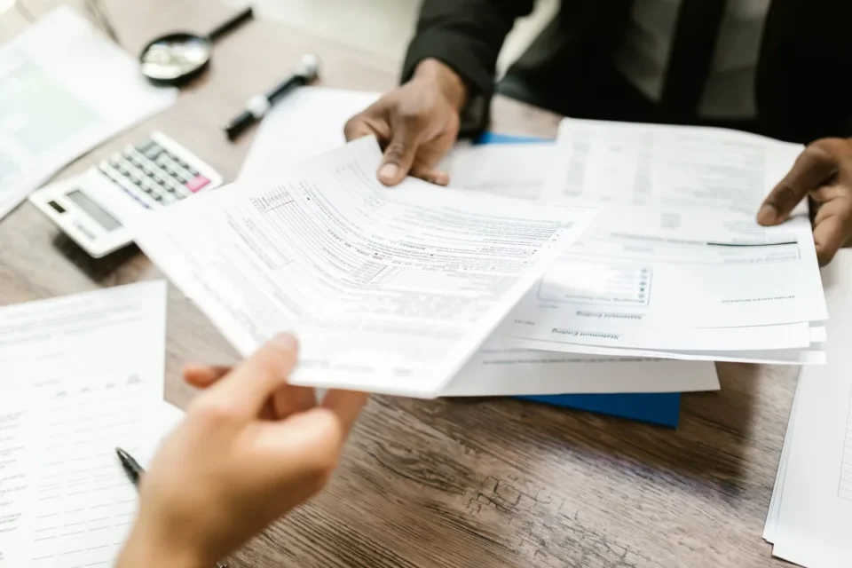 Documents d'assurance, photos de sinistre et stylo sur un bureau