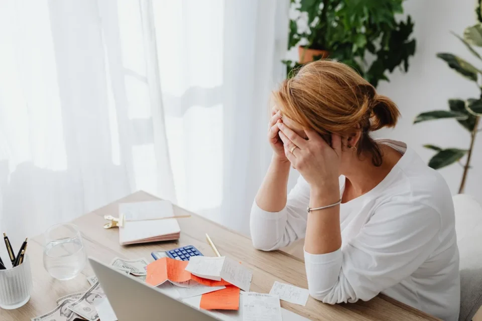 Espace de travail d'un freelance avec laptop, factures et calculatrice sur un bureau organisé