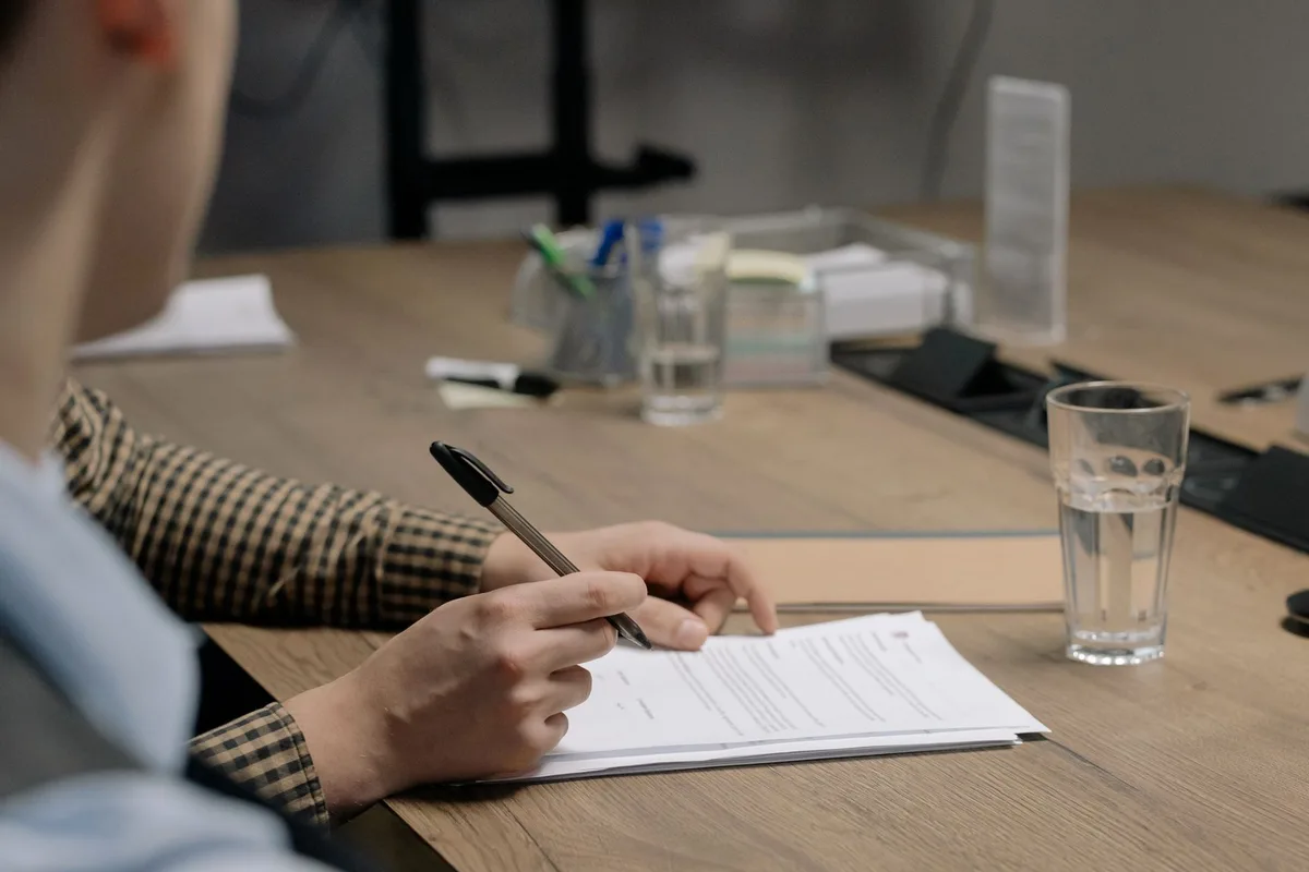 Rédaction d'un contrat CDI sur un bureau professionnel avec documents et stylo