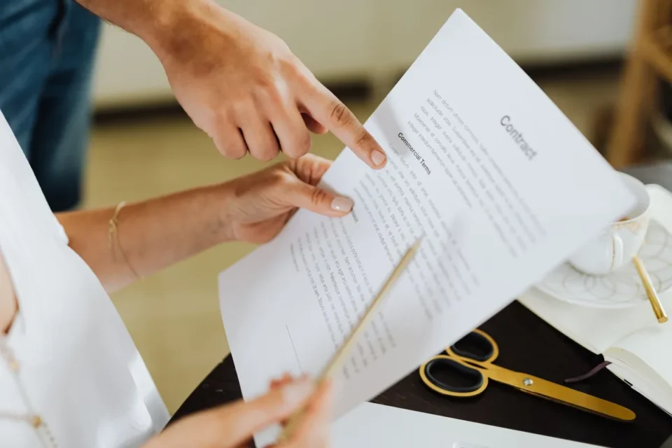 Stylo sur un formulaire de contrat avec calculatrice et lunettes sur un bureau