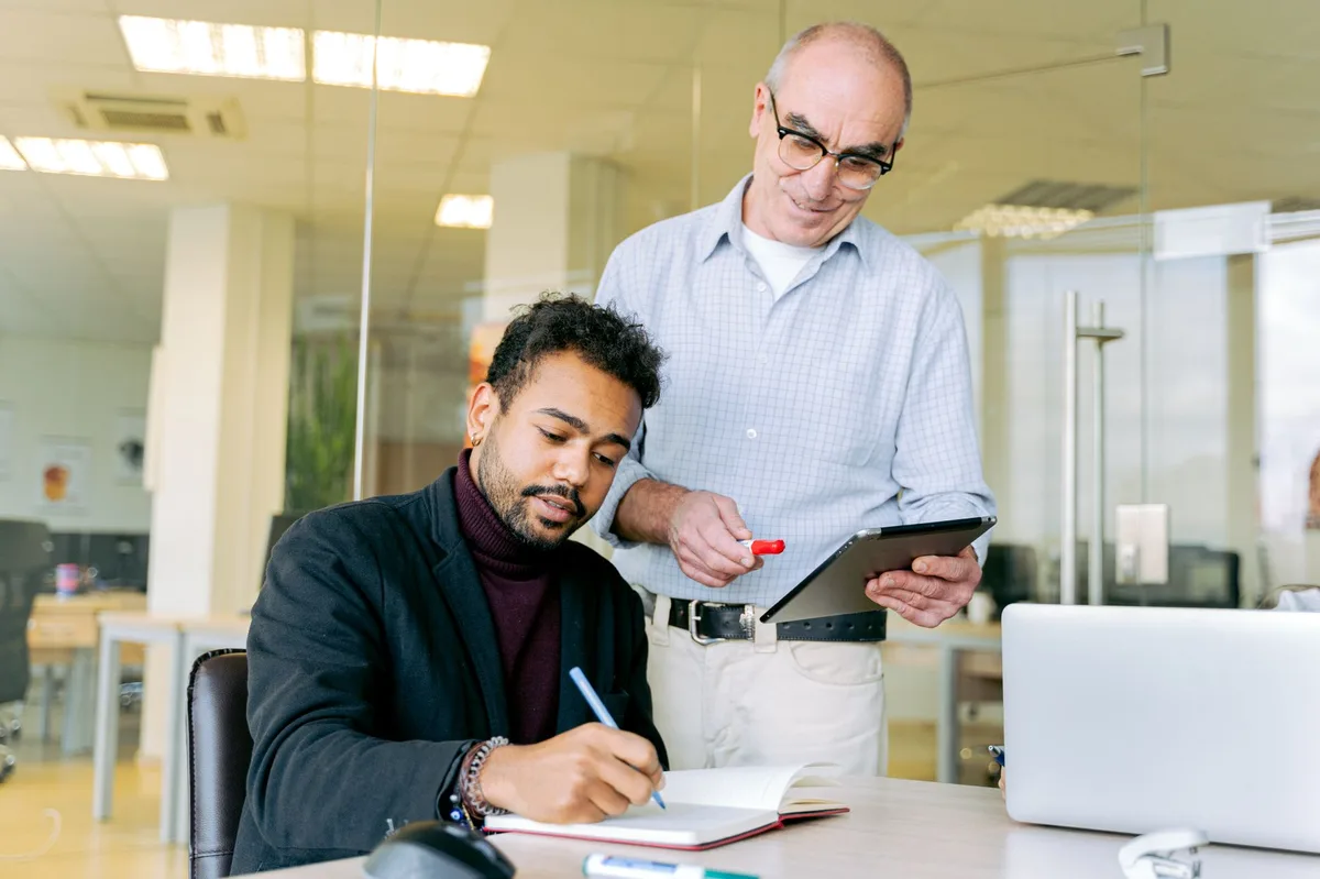 Manager observant un employé en situation de travail pour évaluer l'application de la formation