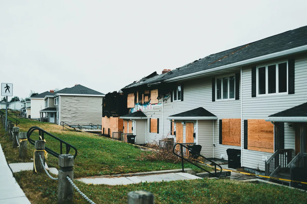 Expert en assurance inspectant des dégâts immobiliers avec prise de notes