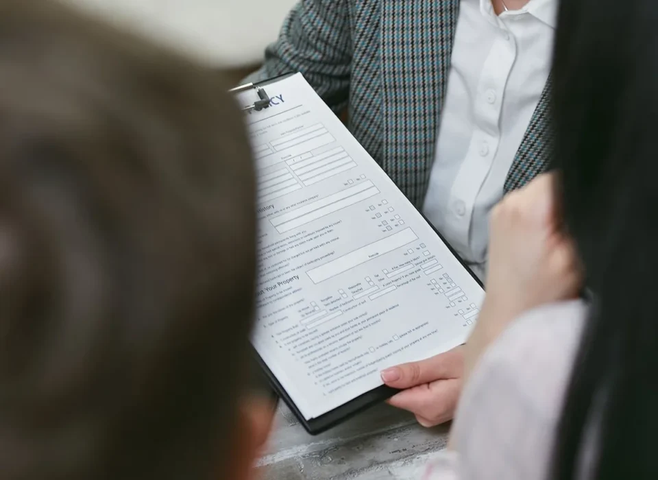 Dossier de sinistre avec photos de dégâts d'eau et documents d'assurance sur table