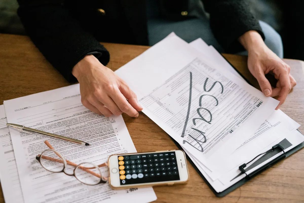 Documents juridiques, calculatrice et relevé financier pour évaluer les coûts du licenciement