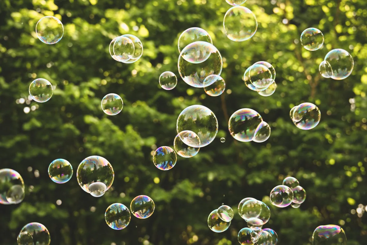 Illustration symbolique d'une bulle qui éclate avec des pièces de monnaie et des graphiques