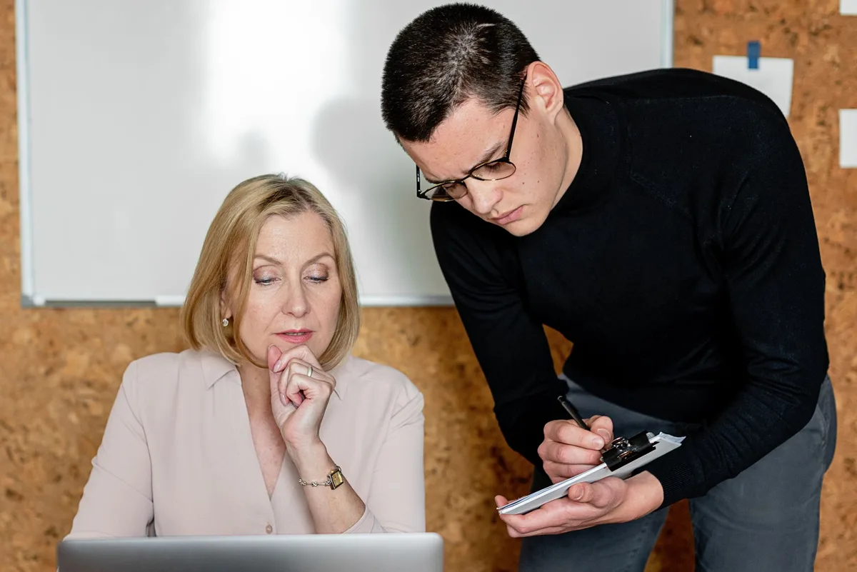 Deux personnes en discussion professionnelle autour d'un bureau