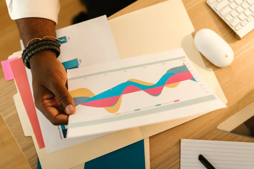 Mains tenant un rapport sur l'emploi avec graphiques et chiffres sur un bureau