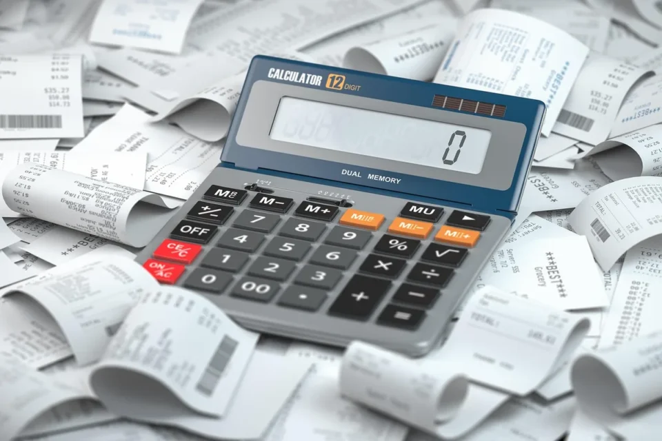 Factures et documents comptables sur un bureau avec calculatrice et stylo