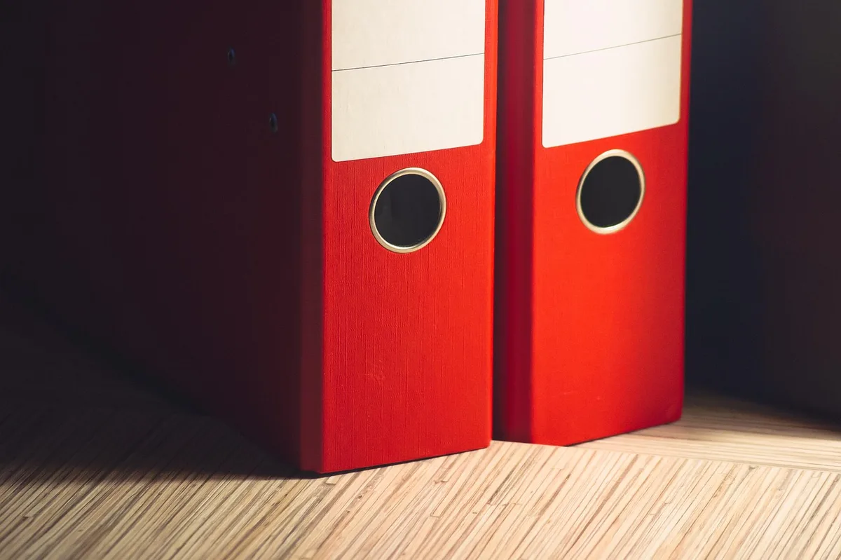 Dossier avec documents organisés, factures et preuves rassemblées sur un bureau