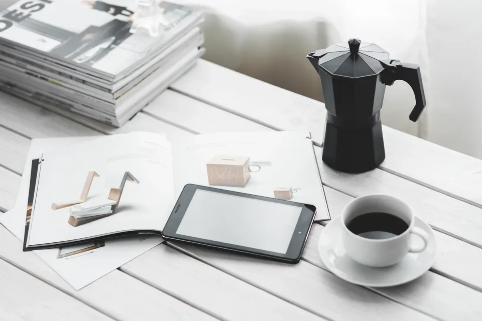 Personne comparant des devis d'assurance habitation sur un bureau avec des documents