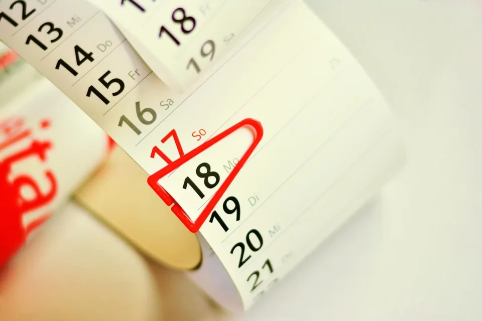Calendrier avec une date marquée au stylo et documents comptables sur un bureau