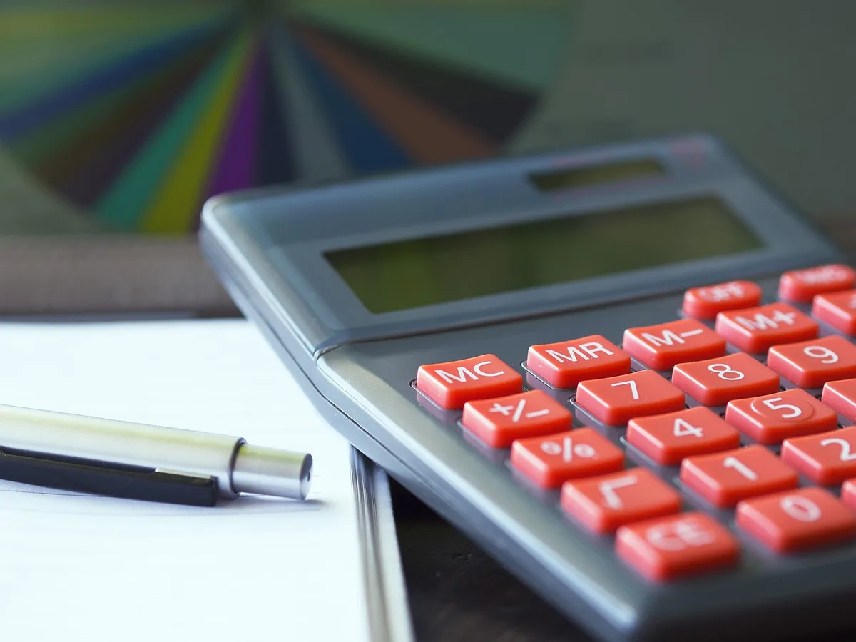 Calculatrice et documents fiscaux sur un bureau ensoleillé