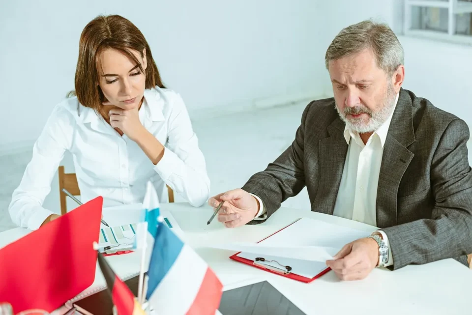 Réunion d'équipe autour d'une table de conférence avec documents et échanges constructifs