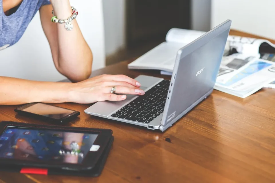 Bureau en journée avec clavier, écran de tableau de bord flou et mains tenant une facture