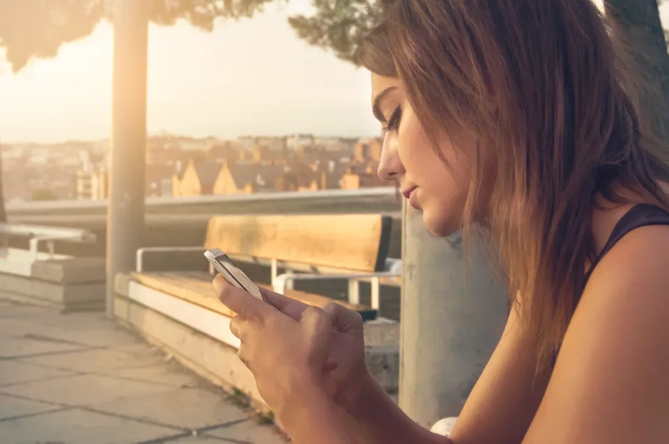Nouveau collaborateur utilisant un smartphone lors d'une réunion d'onboarding en plein jour