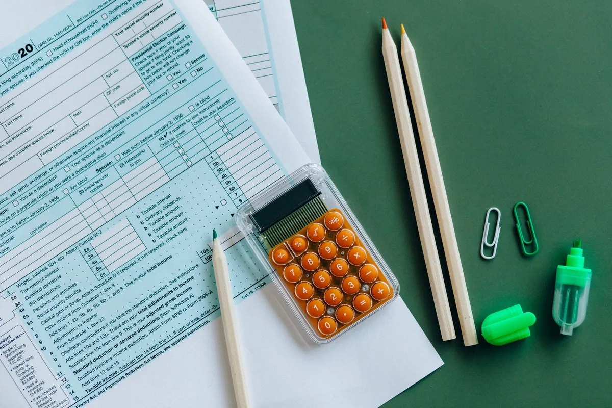 Documents fiscaux et calculatrice sur un bureau ensoleillé