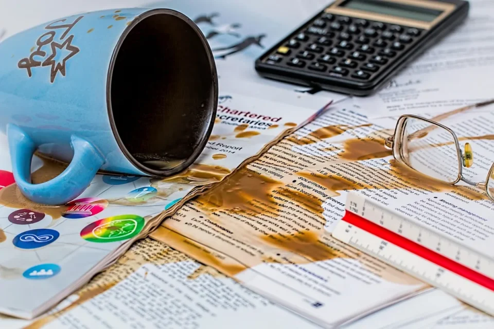 Deux paires de mains sur des documents et un petit modèle de maison dans un bureau en journée