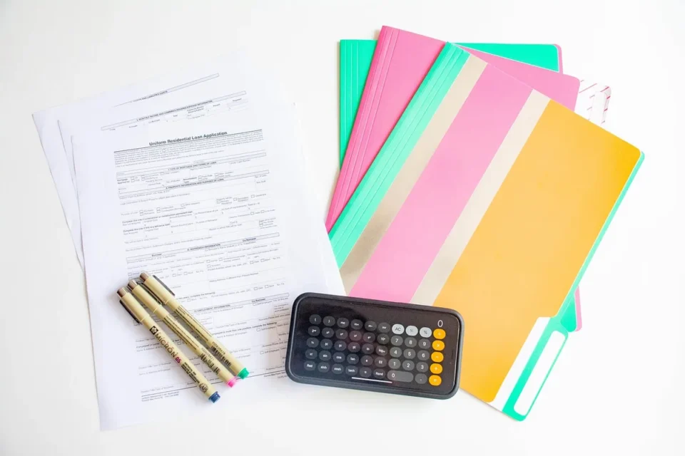 Papiers d'assurance et calculatrice sur un bureau en plein jour