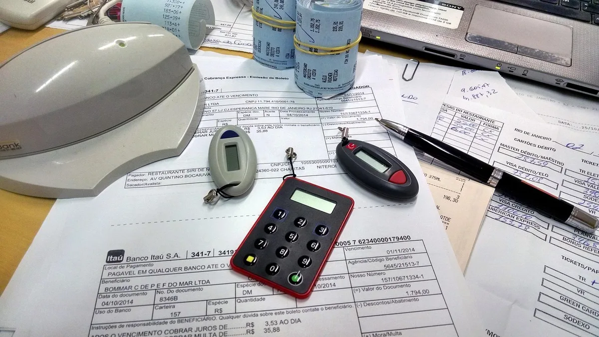 Mains posées sur des documents de prêt et une calculatrice
