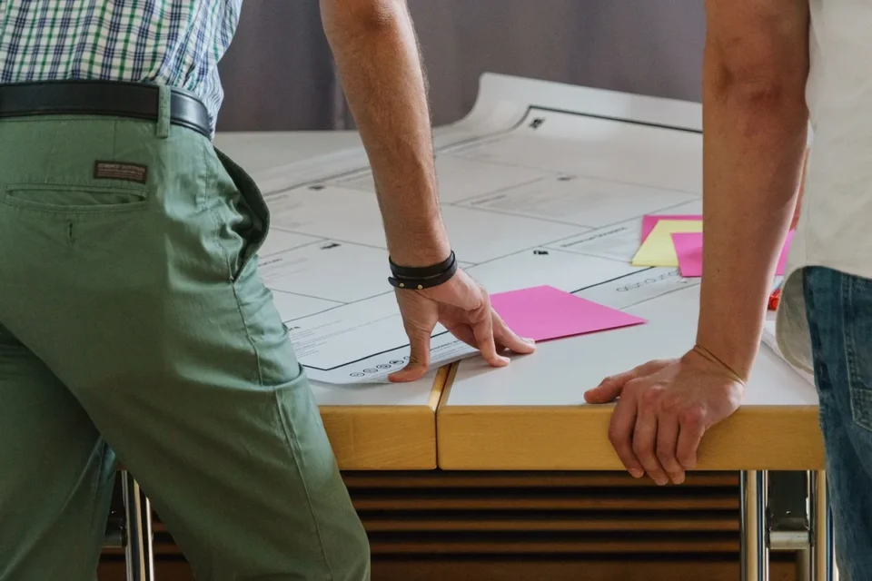 Espace de réunion lumineux avec questionnaire, notes autocollantes et mains anonymes sur une table