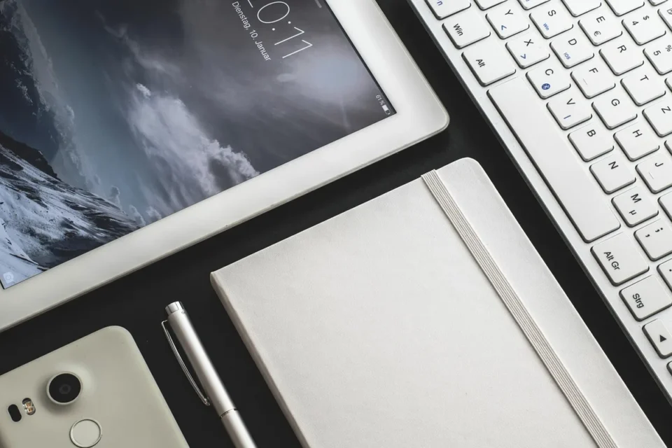 Serveur consultant un module de formation sur smartphone à côté d'une fiche allergènes sur une table en journée