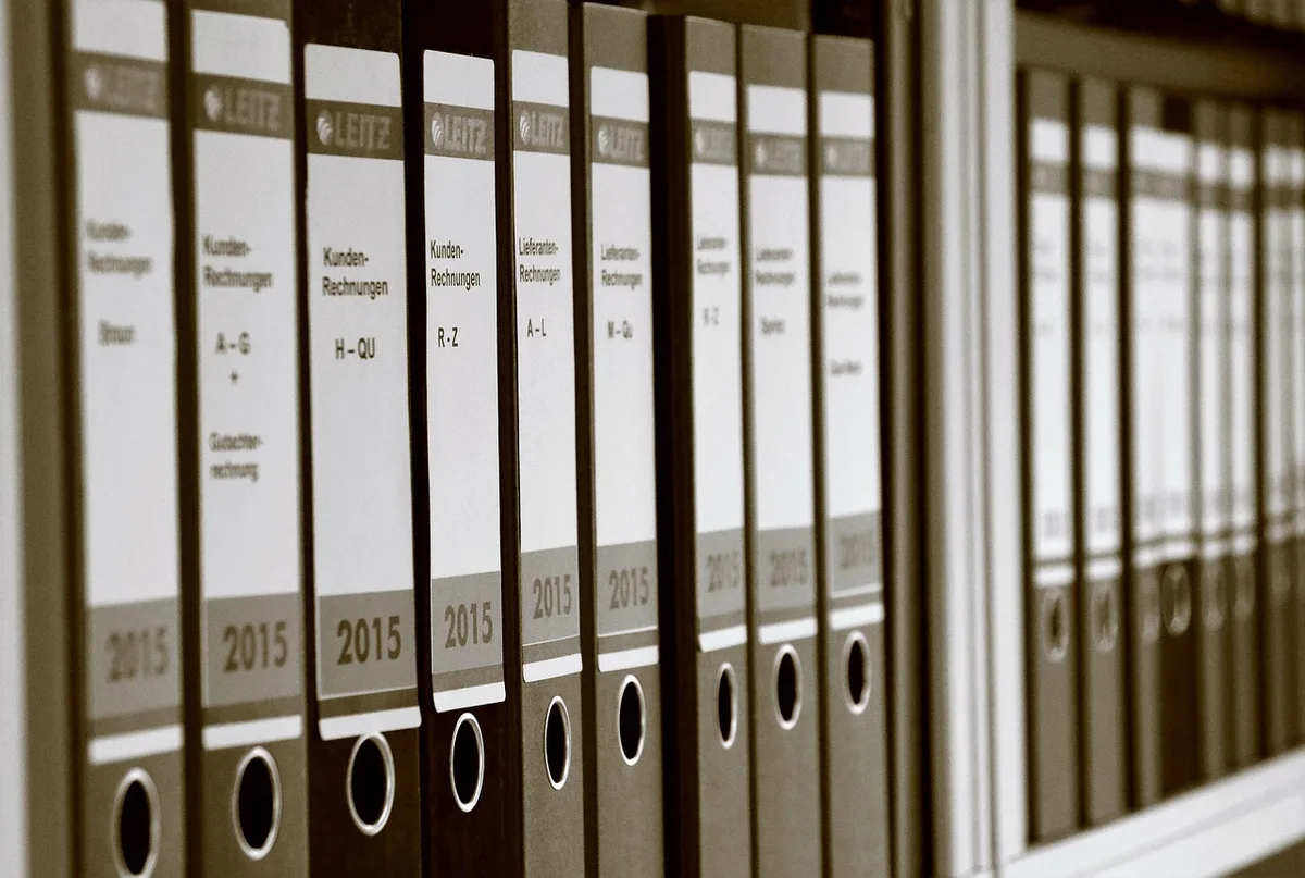 Documents comptables et facture sur un bureau éclairé par la journée