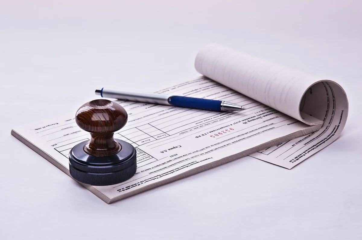 Factures et reçus sur un bureau pour illustrer charges déductibles et tenue de comptabilité